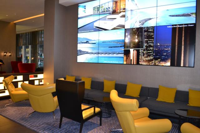 Dans le lobby, un mur d'informations lumineux, l'un des nouveaux marqueurs de Pullman.
