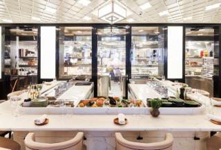 Le Sea Bar, comptoir de marbre avec vue sur les cuisiniers préparant chaque plat minute autour des...