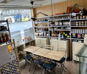 Quelques simples tables en bois au coeur de l'épicerie, efficace et insolite.