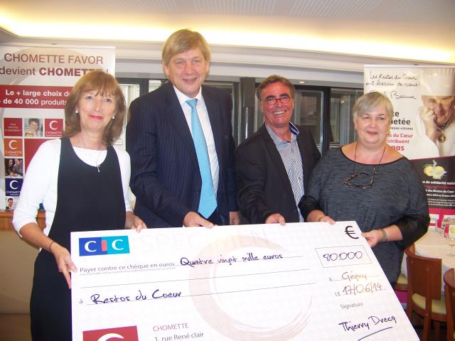 Thierry Drecq (à gauche), président du groupe ECF, et Eric Le Judec, président de Mark & Styl, remettent le chèque aux bénévoles des Restos du Coeur Rhône.