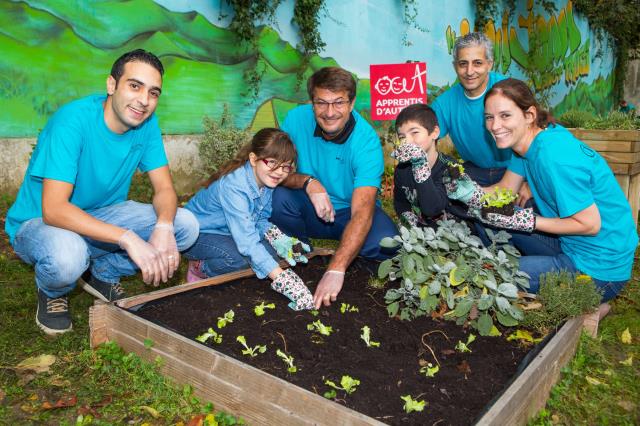 Jean Faivre, , vice- président Europe du Sud et de l'Ouest d'Hilton (au centre), avec les employés du Hilton Paris-Orly et les enfants des Apprentis d'Auteuil.