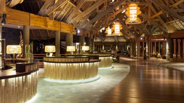 Dès le lobby, le ton est donné : coiffé d'une charpente bois couverte de paille la plus haute du pays, l'accueil du resort revisite l'histoire locale, avec en son coeur l'incontournable espace à palabre.