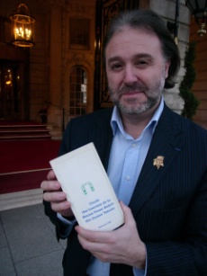 Philippe Faure Brac devant le Ritz avec l'annuaire des lauréats de la bourse Evian Badoit