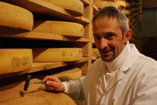 L'affineur Claude Querry tape la meule avec le manche de sa sonde. 'J'écoute ce que le Comté me raconte.' Avec la partie métallique, la sonde permet de prélever un petit morceau de Comté afin de juger de sa texture, de son odeur et de son goût.