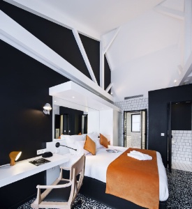 Pour le mobilier, il est important de conserver une cohérence. Ici, les propriétaires ont apposé un sol façon QRcode pour rester dans l'esprit high-tech présent de la chambre. Hôtel Faubourg 88.