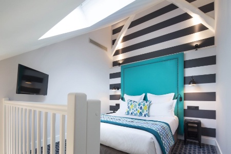 Textile : le sol, le jeté de lit et un coussin rappellent la couleur bleue mise en avant avec la tête de lit. L'Hôtel Fabric à Paris.