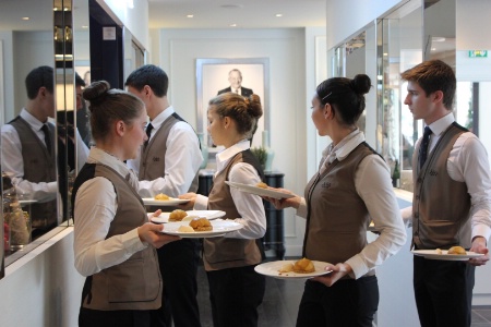 Les jeunes ont une visibilité totale sur les différents locaux : pâtisserie, cuisine, salle et office. Portrait de Gérard Pélisson en arrière-plan.