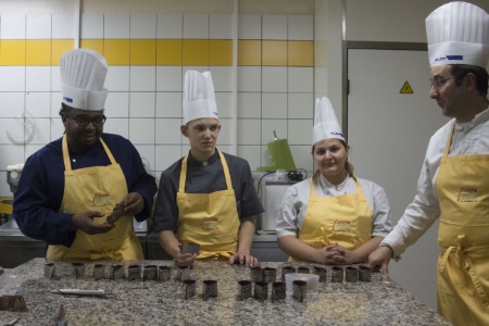 Aurélien Dubois fait découvrir à trois élèves comment travailler le chocolat pour alléger un dessert.