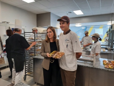 Carole Grandjean, ministre déléguée chargée de l'Enseignement et la Formation professionnels, posant avec un élève en apprentissage dans le domaine de la pâtisserie.