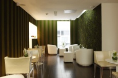 Le lobby, avec ses murs vert sapin et son mobilier uniformément blanc.