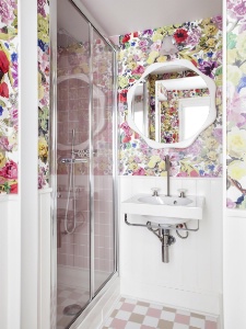 Le papier peint à fleurs dans les salles de bain donne un esprit 'campagne à Paris'.