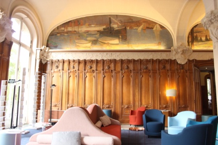 Le hall d'accueil est habillé de lambris, de chapiteaux et culots en stucs, et de peintures d'époque.