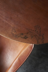 Tatouage sur le cuir d'une tables du restaurant.