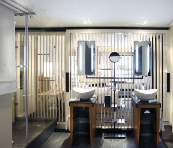 Dans cette salle de bain de l'hôtel Five Seas à Cannes, des tablettes accueillent les affaires. La luminosité naturelle et celle des miroirs offrent un double éclairage.