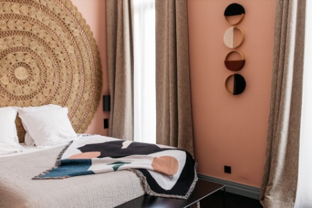 Au mur de cette chambre rose et turquoise, on retrouve les loops pattern de Vanessa Bouzigues, et d'immenses tapis en jute naturelle en guise de têtes de lit.