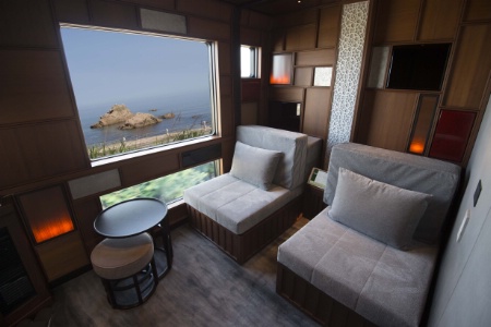 Chambre avec vue et canapés-lits, dans le train-hôtel japonais.
