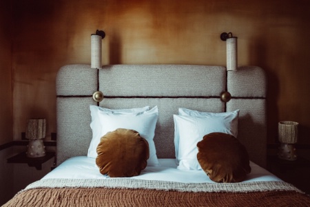 Une chambre de l'hôtel Babel, à Paris (XXe), aux murs recouverts d'une patine ocre réalisé par l'atelier d'art Rosatelier.