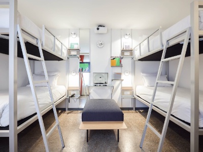 Rétroprojecteur, écran de 150 x 200 cm et Google Chromecast dans une chambre-dortoir de l'hôtel French Theory, à Paris.