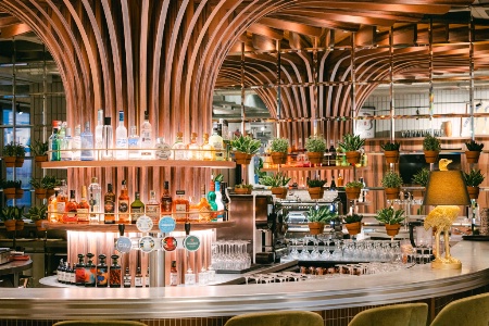 Le spectaculaire meuble en bois cintré du bar du Kopster Colombes.