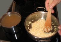 3. Ajouter le riz et mélanger soigneusement. Nacrer les grains de riz : le grain de riz va blanchir, son enveloppe se craquelle et s’enrobe d’huile. Ainsi, il va mieux absorber le liquide et ne collera pas.
