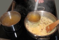 5. Saler au gros sel en tenant compte de l’assaisonnement du bouillon utilisé. Le vin blanc étant complètement évaporé et absorbé, ajouter du bouillon bouillant à hauteur et remuer.