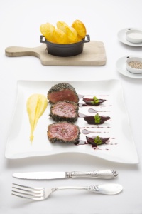 Le filet de boeuf sur le bois et sous les feuilles, jus de viande et jus de raisin, pommes crémeuses et pommes soufflées Le filet de boeuf sur le bois et sous les feuilles, jus de viande et jus de raisin, pommes crémeuses et pommes soufflées