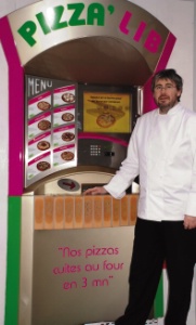 Gilles Renard devant un des distributeurs automatiques de pizzas.