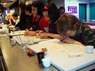Sept enfants malvoyants apprenent à faire un nem au fromage à l'atelier de cuisine Philippe Lechat, Halles Paul Bocuse de Lyon