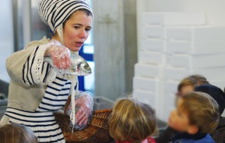 Nathalie Beauvais grimée en Majiknath fait découvrir les poissons aux enfants à la criée de Lorient.