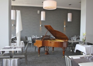 Un piano Pleyel trône au milieu de la salle de restaurant.