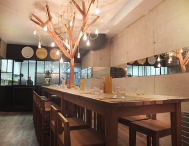 Au sous-sol et face à la cuisine ouverte, une longue table d'hôte (18 places) a été fabriquée avec du bois de récupération.