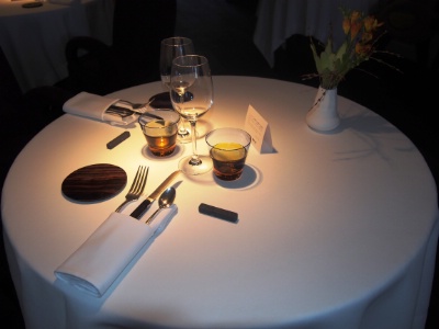 La table : pochette à couverts, pierre de sorax, assiette à pain en bois, verre à eau et verre à vin à pied.