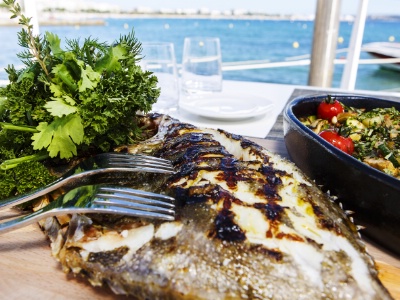 Pagre grillé au four, purée de pommes de terre, salade d'herbes et sauce vierge aux agrumes.
