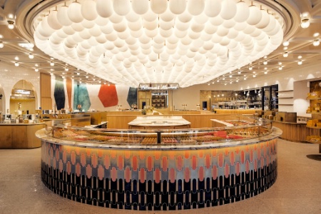 86Champs s'ouvre sur un îlot central de pâtisseries sous une sculpture suspendue de mille ballons en verre soufflé.