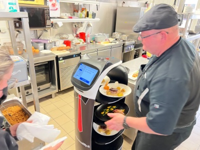 Le cuisinier dépose les assiettes sur les plateaux du robot et appuie sur la destination : rang 1, rang 2, etc.