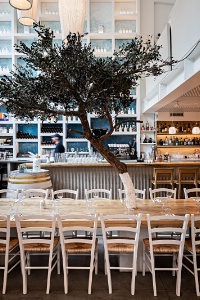Une déco bleue et blanche, un immense bar, une table d'hôtes et l'olivier symbolique.