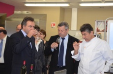 Régis Marcon, à droite, donne les clés de la dégustation d'un vin lors de la visite du lycée. Ses élèves : le ministre Luc Chatel et le président de l'Umih, Roland Héguy.
